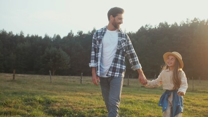 Bearded Caucasian man picking up his little daughter. Starting spinning beloved child in circles....