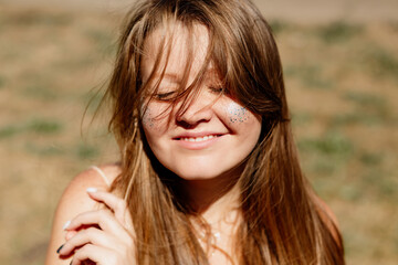 portrait of a young woman with long brown hair enjoying the summer sun, meditating