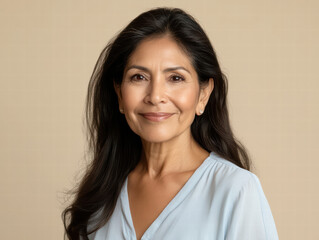 Fototapeta premium Radiant Portrait of Grace: A mature woman with a warm smile gazes directly at the camera, her eyes sparkling with wisdom and contentment. Captured in a timeless moment.