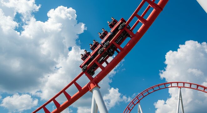 Thrilling Rollercoaster Ride Under Blue Sky - Red rollercoaster car ascends a steep curve against a bright blue sky dotted with fluffy white clouds. Exciting amusement park adventure