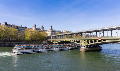 Naklejka premium Une péniche de tourisme, sur la Seine, sous le pont de Bir-Hakeim. La photo est au format horizontal.