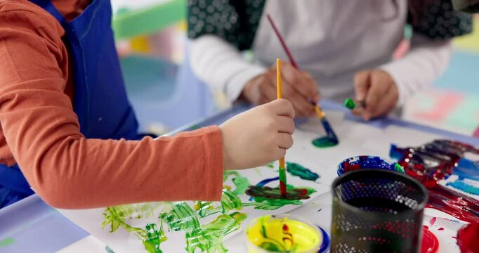 Hands, kids and painting art in classroom for creative lesson, colorful drawing or kindergarten learning. Artist, student or picture with fun activity, project creativity or motor growth of education