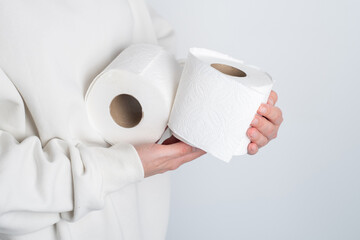 Woman's hands holding soft white toilet paper roll. Hygiene concept. Close-up