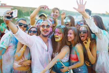 Happy friends having fun on the sunset beach. Group of friends spending time together, celebrating...