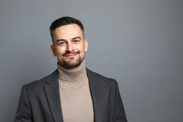 Portrait of handsome middle aged man on grey background, space for text