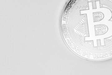Minimalist close-up of a silver Bitcoin coin on a clean white background, symbolizing digital currency, cryptocurrency, and modern financial technology.
