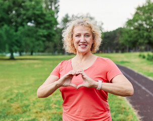 mature fitness woman heart active love sport exercise healthy fit health middle aged shape female...