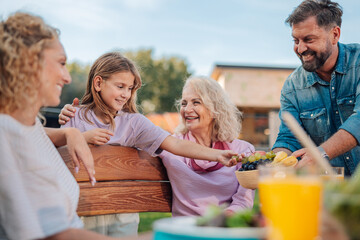 Happy family enjoying outdoor meal together in backyard