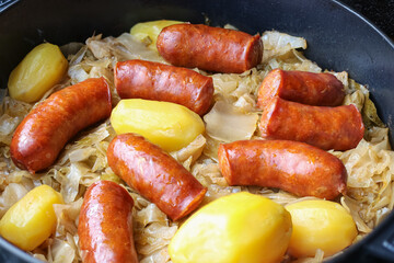 Traditional Cooked Sausages with Potatoes and Cabbage in a Pan