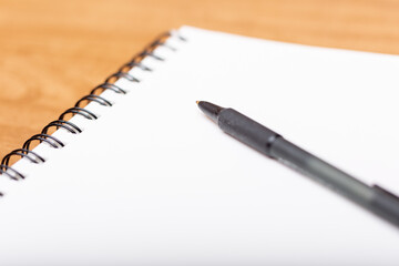 Blank white notebook with black pen for writing