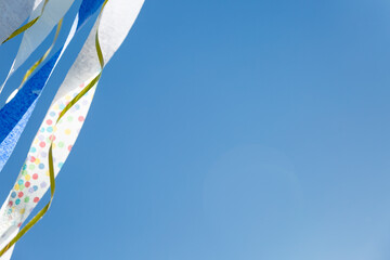 Blue sky background with paper crepe streamers in corner
