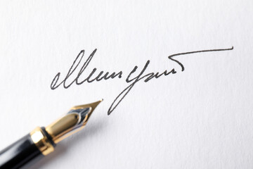Fototapeta premium Fountain pen and signature on white paper, closeup