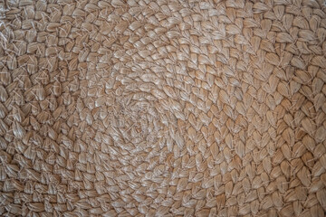 A close up of a woven rug with a brown and tan color scheme