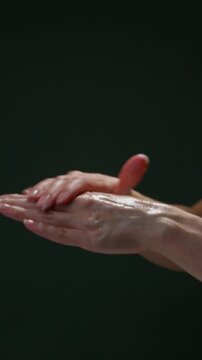A woman is applying some hand cream. сlose-up. vertical video 