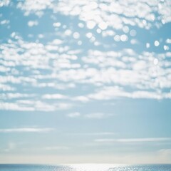 Softly blurred blue sky with light white clouds, dreamy and clean, bokeh effect ideal for inspirational quotes or wellness designs, large empty area in center.