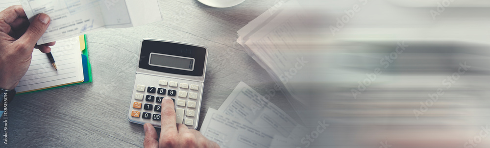 Aufkleber business person calculating invoices using calculator in office