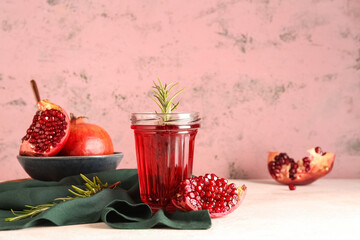 Bowl with fresh pomegranate and glass of juice on white table