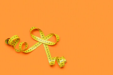 Yellow measuring tape on orange background