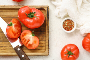 Wooden board with fresh tomatoes on white background