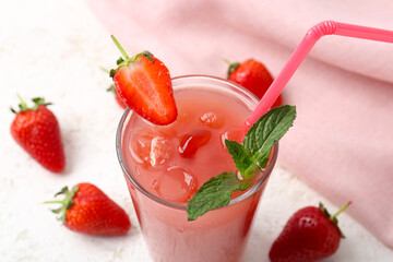 Glass of tasty strawberry juice on white table
