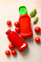 Bottles of ketchup and tomatoes on white background