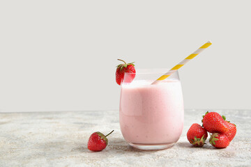Glass of tasty strawberry smoothie on table