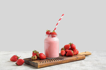 Mason jar of tasty strawberry smoothie on table