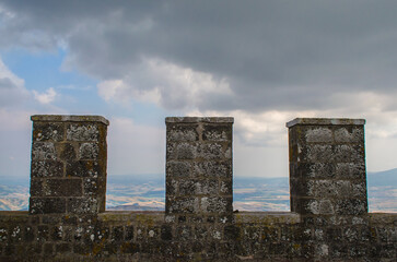 Panorama dalla torre di Radicofani, borgo in Toscana lungo la Via Francigena, con tre merli fortificati in primo piano