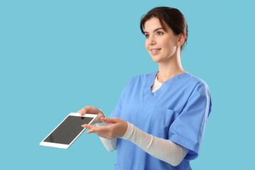 Female medical intern with tablet computer on blue background
