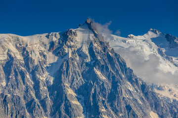 Aiguille du Midi peak in the Alps. Chamonix valley landscape of a prominent rocky towering mountain peak in French Alps. Chamonix-Montblanc area beautiful landscape of Aiguille du Midi summit, France