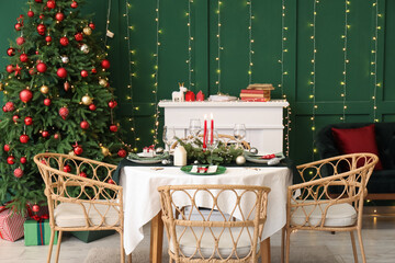 Festive table setting in stylish living room with Christmas tree and fireplace