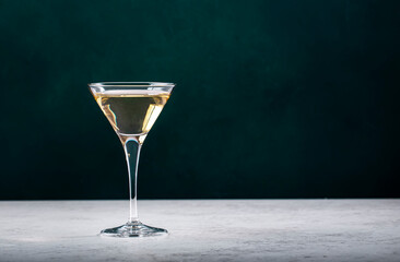 Italian white bianco vermouth in glass on dark green background