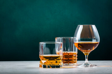 Strong hard alcoholic drinks, spirits, distillates, whiskey and others. Drink background banner. Alcohol set. Green wall