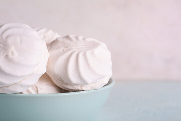 Bowl with delicious marshmallows on table against white background. Closeup