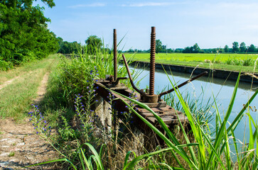 Una vecchia chiusa arrugginita lungo un canale nella campagna vicino a Pavia lungo la Via Francigena
