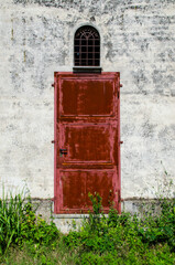 Una porta di metallo dipinta di rosso su un muro bianco
