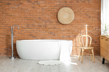 Interior of bathroom with bathtub, chair and pouf