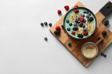Bowl with tasty spirulina smoothie and wooden tray on white background