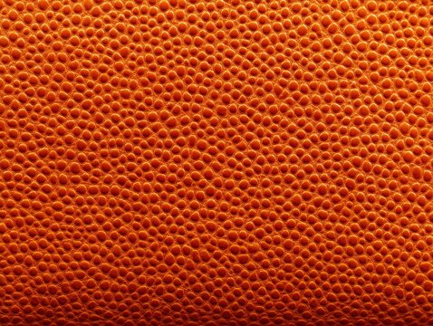 Pattern of small round textures closely resembling a basketball surface with an intricate orange-brown design, displaying a pebbled effect that highlights the material's grain