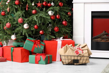 Basket with Advent calendar and presents near Christmas tree in living room