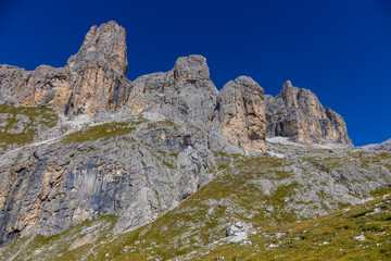 Dolomites, Alpi Dolomiti beautiful scenic mountain landscape under blue sky in summer. Rocky tower peak summits of the Alps on a sunny day. Alpine scenic view of the cliffs and climbing walls in Italy