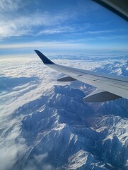 Obraz premium Airplane Wing Flying over Snow Covered Mountain Range