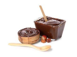 Bowls of sweet chocolate spread and hazelnuts on white background