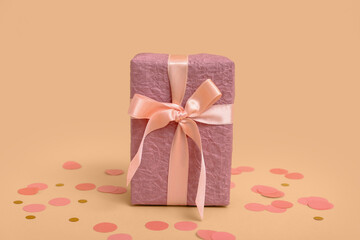 Gift box and confetti on brown background