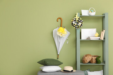 Bench, shelving unit and umbrella in room decorated for Easter celebration