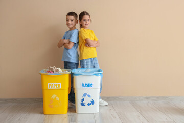 Cute children with garbage containers near beige wall. Global Recycling Day