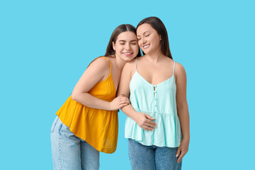 Naklejka premium Beautiful mature woman with her young daughter on blue background. Mother's Day celebration