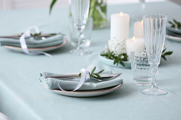 Beautiful table setting for Mother's Day celebration with burning candles and gypsophila flowers in dining room