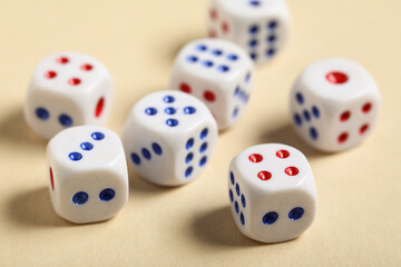 White game dices on beige background, closeup