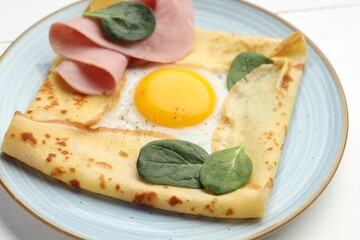 Delicious crepe with egg, ham and basil on table, closeup